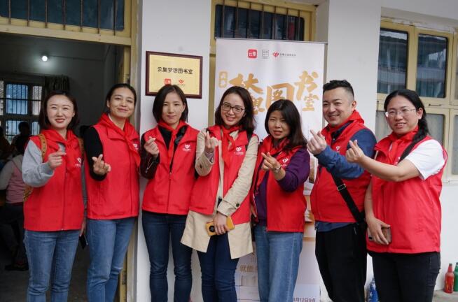 志愿者们在景星小学新挂牌的梦想图书室前合影